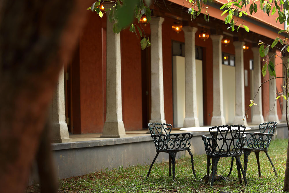 Cast iron garden chairs and table under a colonial-era veranda